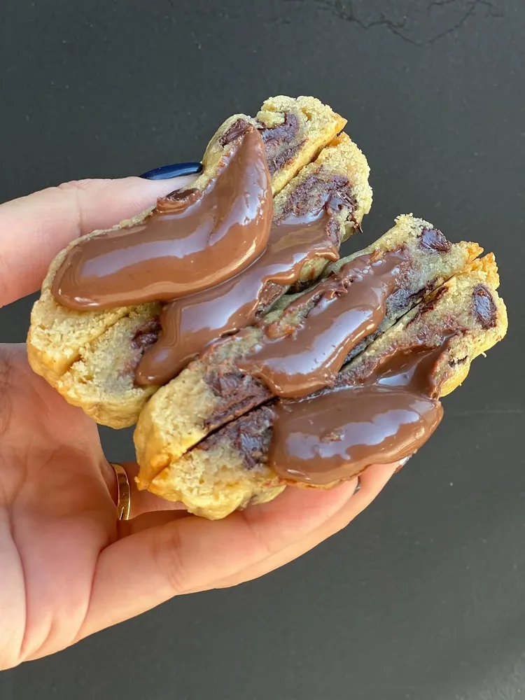 Cookie partida por la mitad, rellena de crema de chocolate
